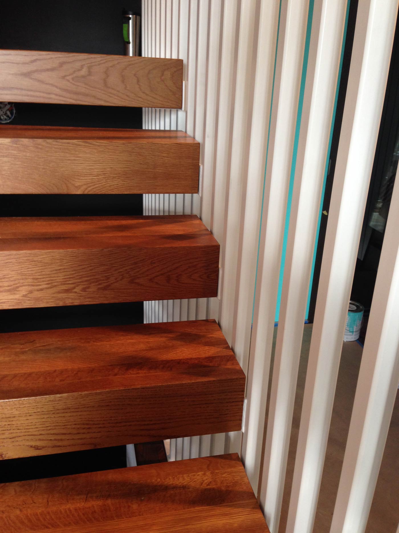 Oak stair trends tie in with one-inch square tube steel verticals in new staircase design.