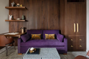 Sofa in front of wall with wood paneling and shelving